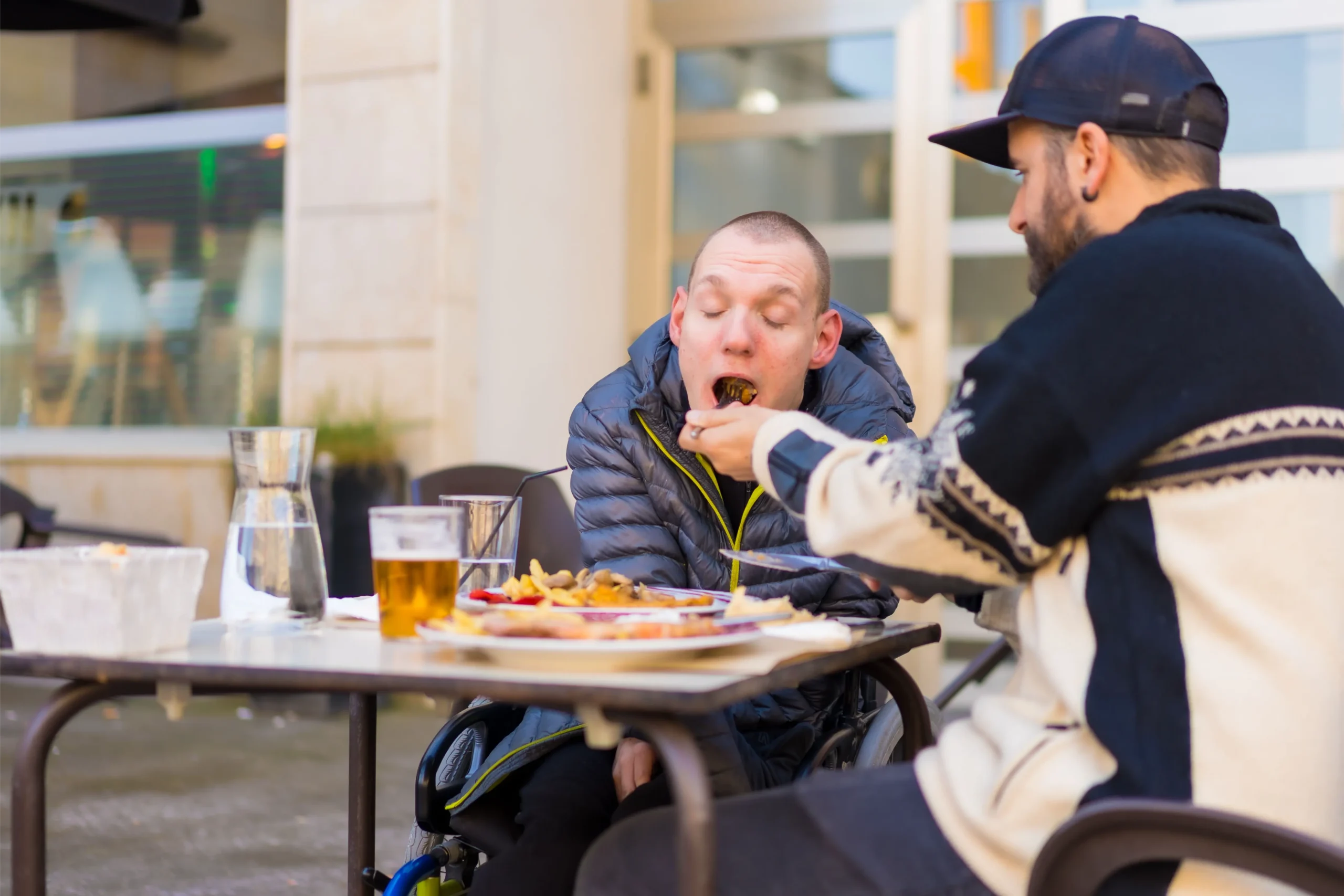 Friend supporting another friend at an outdoor cafe